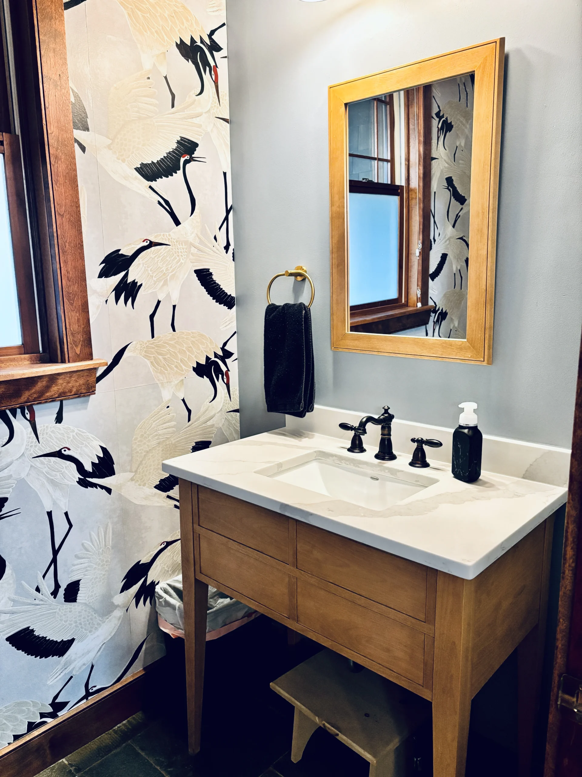 Half bath located on the first floor. We couldn't resist putting in some heron wallpaper!